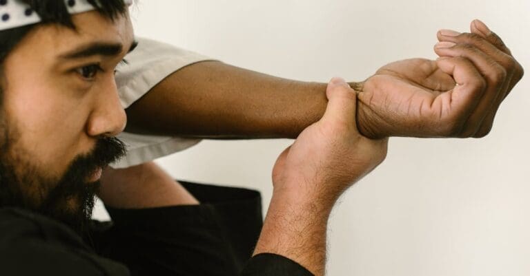 A close-up of a martial arts practitioner demonstrating teen self-defense skills by performing a precise wrist-lock escape maneuver.