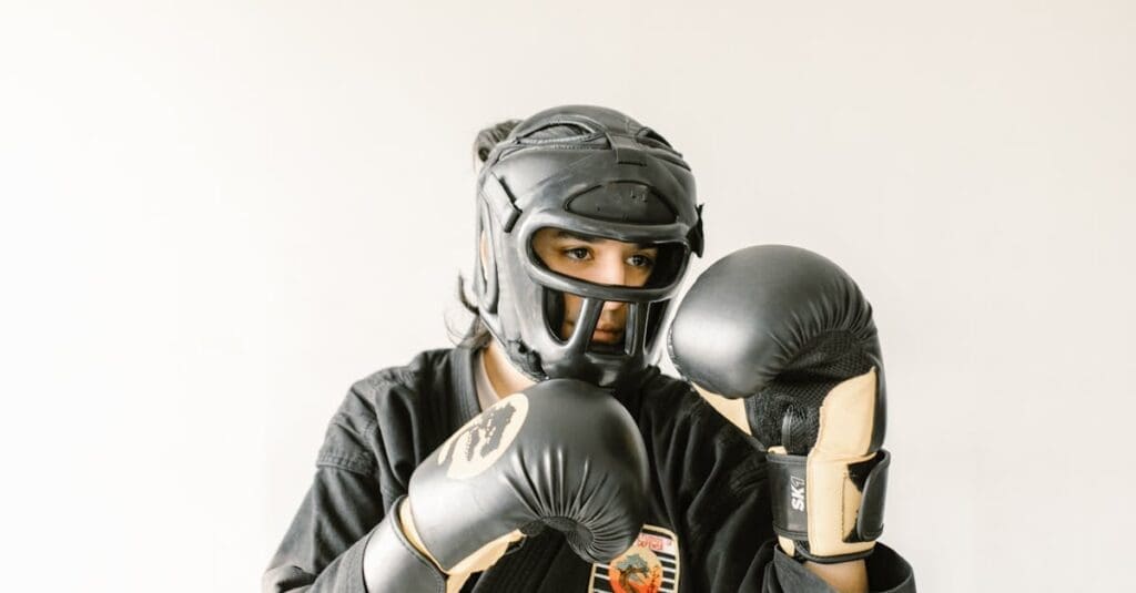 A student wearing a protective headguard and boxing gloves practicing striking-based teen self-defense skills.