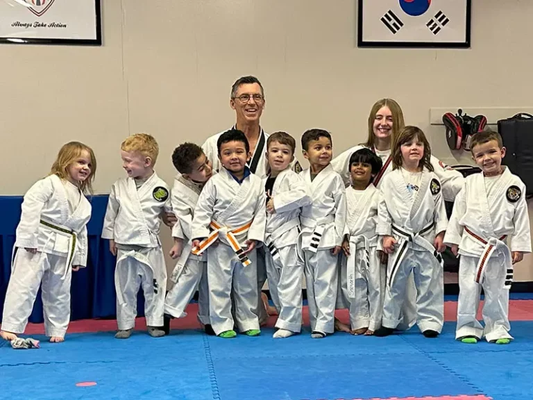 Three preschoolers holding stances to build preschool martial arts skills