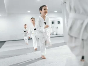 Smiling preschooler running drills during beginner martial arts for kids